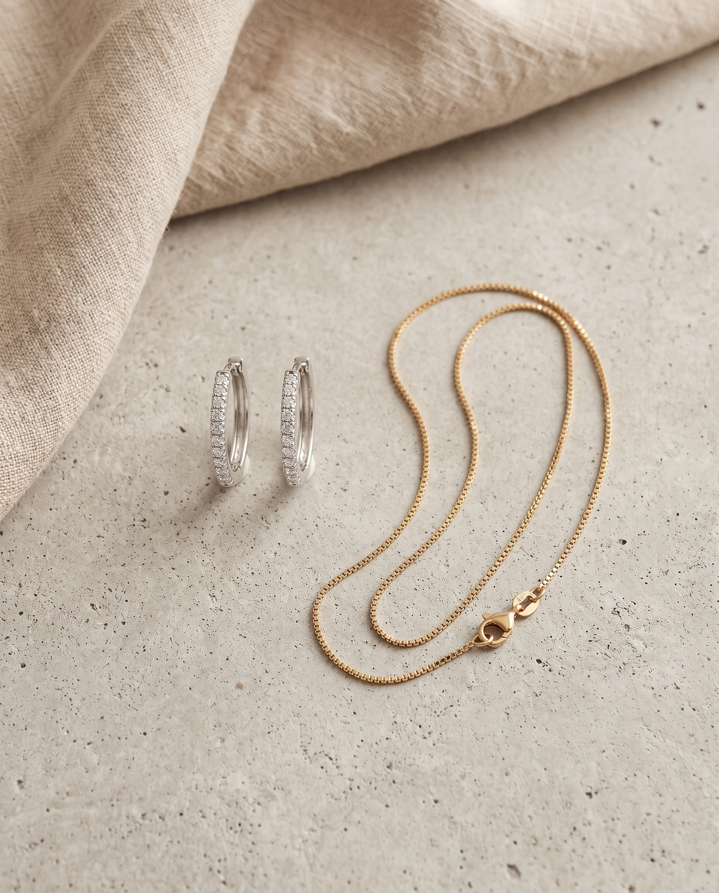 Bridal Glow Set Flatlay: silberne Pavé Creolen und feine vergoldete Halskette