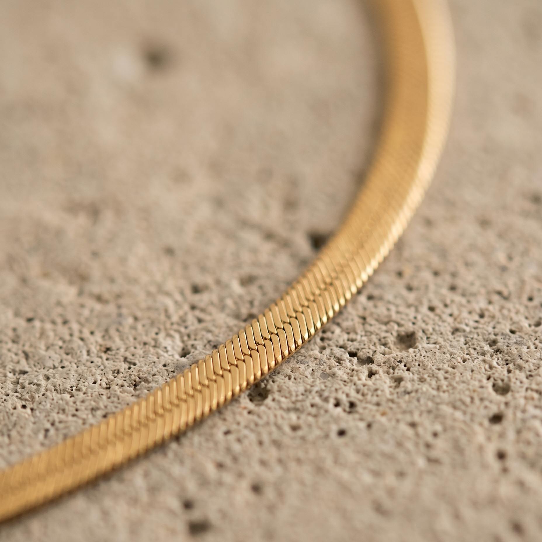Makro-Detail der flachen Schlangenkette in Gold (Fischgrät)
